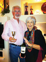 Fred and Susan Henderson display the Tuesday Taster’s award winning wine for the month of April.