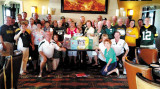 Wisconsin Club members got together at The Grill for fun, football and food. They are shown with the many school supplies they donated and gave to the After Schoolers group for local children.