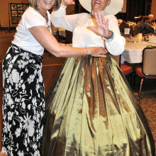 Before calling the meeting  to order, Susan Hebert gets a  minor costume adjustment from Sandy Conwell.