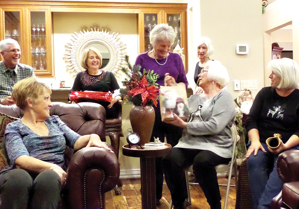 Erna Seale steals Jo Haynes’ gift as Gary Triebsch, Pat Sabo, Lee Mallicone, Eve Draper and Mary Arthur look on.