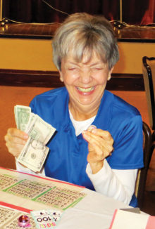 Joan Petre grinning ear to ear over her Bingo winnings
