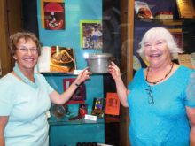 Left to right: Carol Solow and Mary Mullins point to an early pressure cooker.