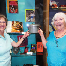 Left to right: Carol Solow and Mary Mullins point to an early pressure cooker.