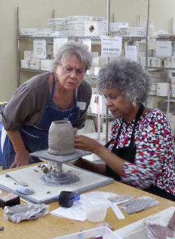 Caroline Detjen teaches Trinka Taylor how to make a teapot.