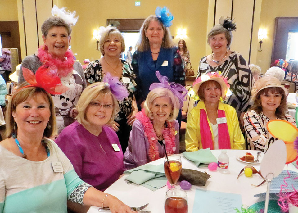 Women’s Club members enjoying the April luncheon while wearing their fashionable fascinators and bonnets