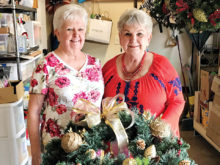 Sally Baggott and Jan Utzman creating the wreath centerpieces for the Hearts for Homes fundraiser event