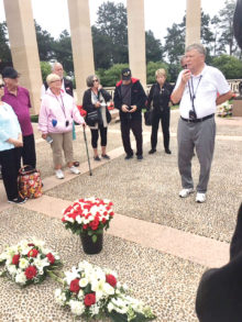 SOT President Mike Hoernemann delivers remarks to the 60 SOT travelers during the wreath laying ceremony. The roses in the foreground were later placed on individual graves by the members.