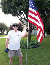 Quinn Sowell installing a flag for a Robson Ranch patriot.