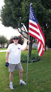 Quinn Sowell installing a flag for a Robson Ranch patriot.