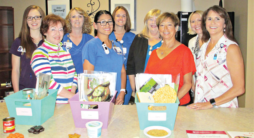 WLN members Tina Hoffenberg, Carolyn Thomas and Ana Corey meet with staff at Presbyterian Hospital’s Diabetes Chronic Care Management Program. Displayed are some of the care boxes given to patients.