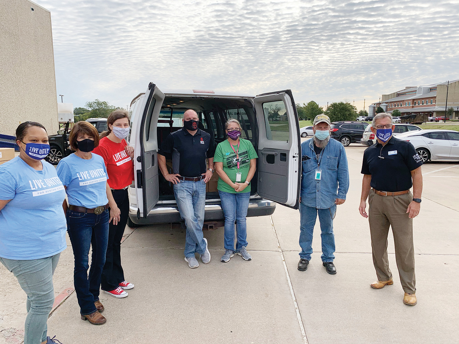 BPS Technology CEO Bravis Brown (center) and United Way of Denton County CEO Gary Henderson (right) and volunteers pose with Denton County Friends of the Family representatives, after loading their van with over 20 cases of hand sanitizer.