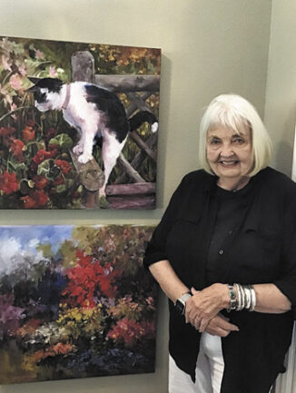 Joan with her oil paintings Curiosity and Summer Garden.
